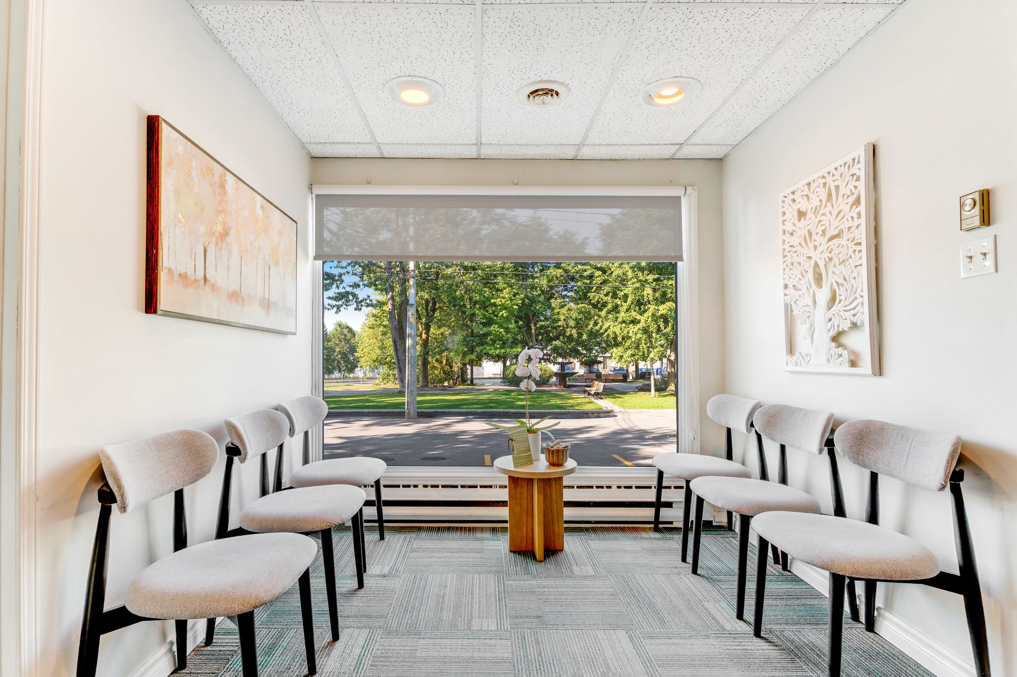 Salle d’attente lumineuse du Centre chiropratique Ste-Dorothée, avec vue sur le parc